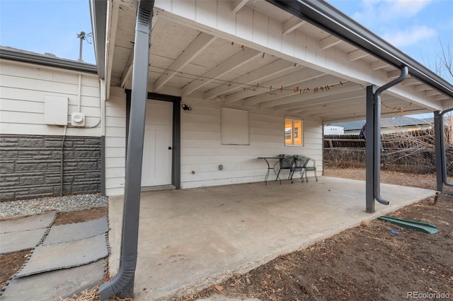 view of patio / terrace with a carport and fence