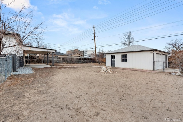 view of yard with an outbuilding, a carport, fence, and a garage