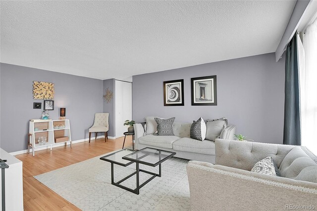 living room featuring a textured ceiling and light hardwood / wood-style floors