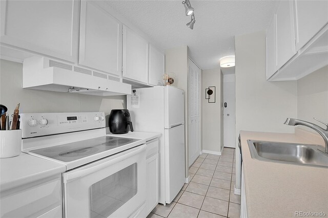 kitchen with custom range hood, white appliances, white cabinetry, sink, and track lighting