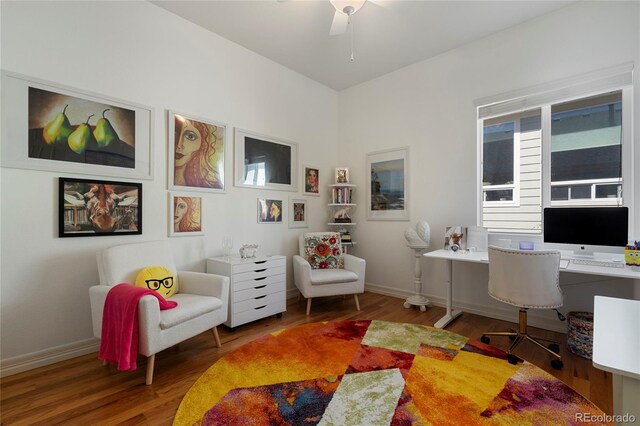 home office featuring wood finished floors, a ceiling fan, and baseboards