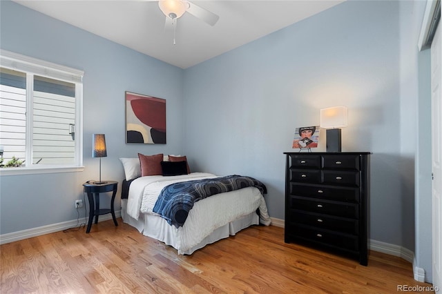 bedroom featuring light wood-style flooring, baseboards, and a ceiling fan