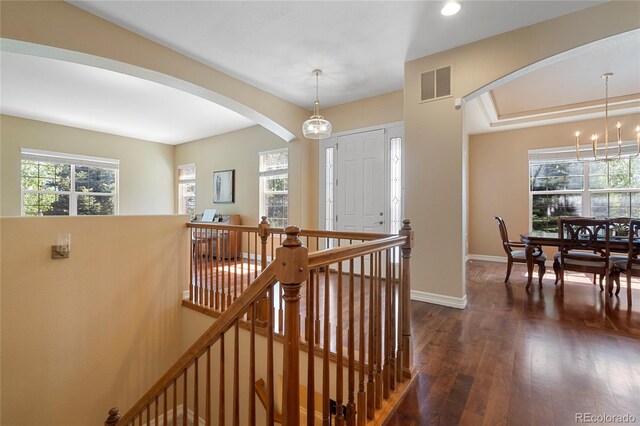 entrance foyer featuring arched walkways, dark wood-style flooring, baseboards, a chandelier, and recessed lighting