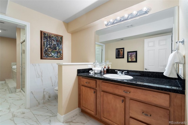 bathroom with marble look tile flooring, a shower stall, toilet, and vanity