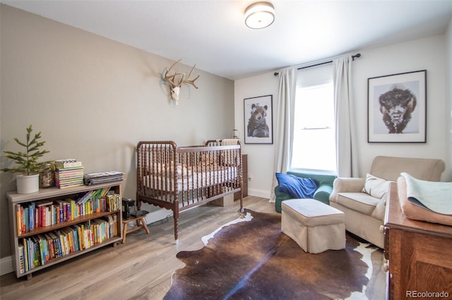 50 S Dickson St, Keenesburg, CO 80643 - bedroom featuring wood finished floors, baseboards, and a nursery area