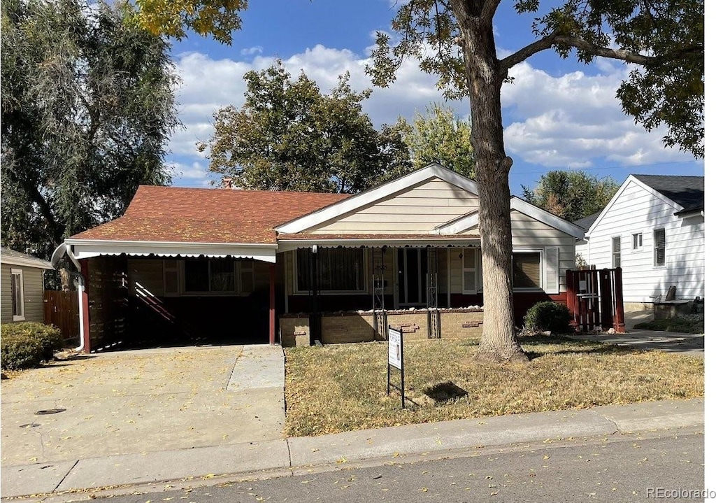 view of front of house featuring a front lawn and a carport