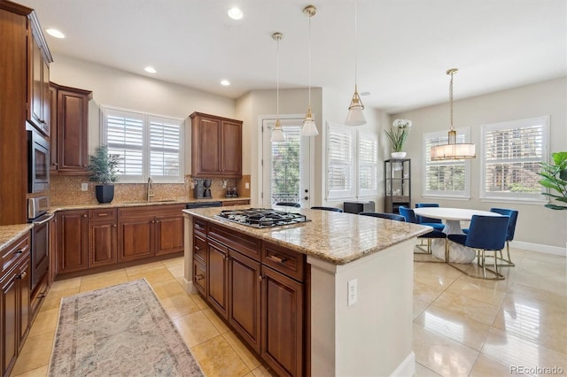kitchen with stainless steel appliances, a sink, a wealth of natural light, and tasteful backsplash