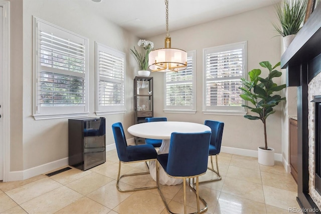 dining space featuring light tile patterned floors, baseboards, plenty of natural light, and a chandelier
