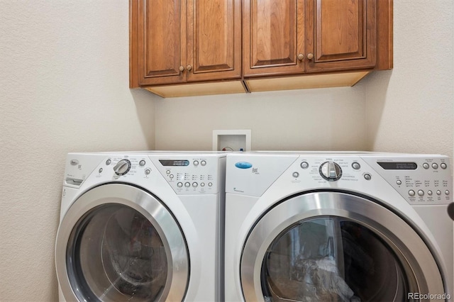 clothes washing area featuring cabinet space and washing machine and clothes dryer