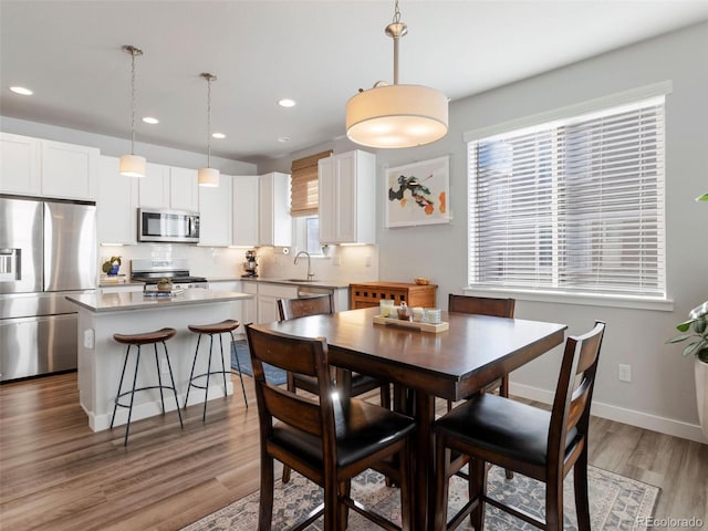 dining room with hardwood / wood-style flooring and sink