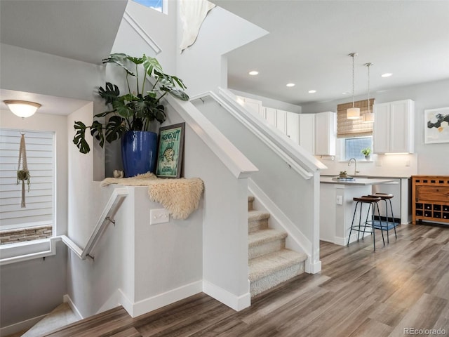 stairs featuring hardwood / wood-style floors and sink