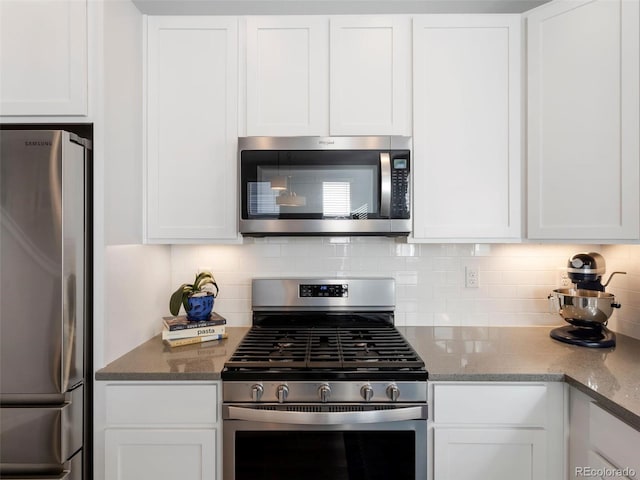 kitchen featuring dark stone countertops, white cabinetry, and stainless steel appliances