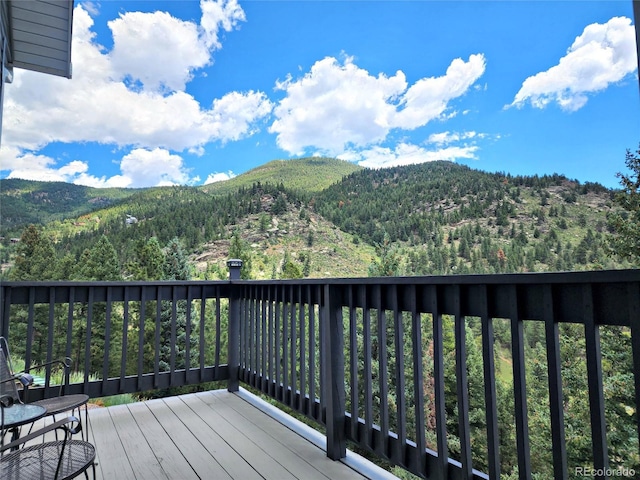 83 Wilderness Cornerstone Rd, Evergreen, CO 80439 - wooden deck with a mountain view and a wooded view