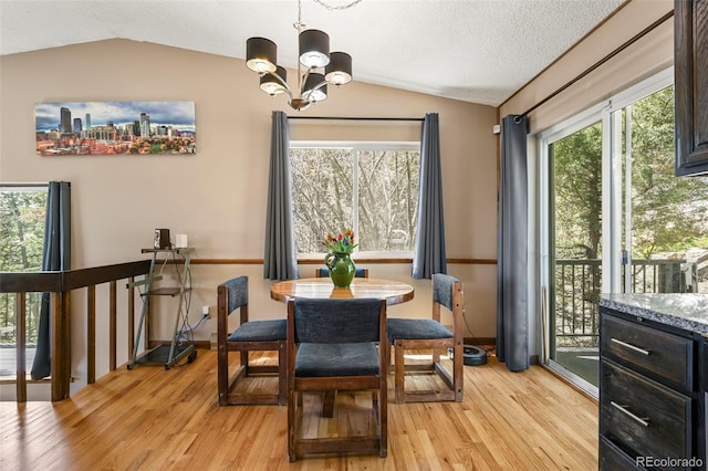 8386 S Davco Dr, Morrison, CO 80465 - dining room featuring lofted ceiling, light wood finished floors, a chandelier, a textured ceiling, and baseboards