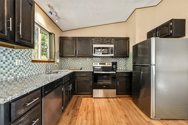 8386 S Davco Dr, Morrison, CO 80465 - kitchen with stainless steel appliances, a sink, a textured ceiling, light wood-style floors, and vaulted ceiling