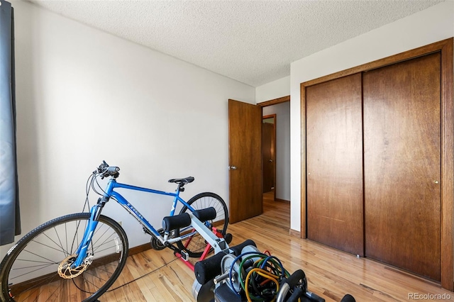 8386 S Davco Dr, Morrison, CO 80465 - exercise room featuring light wood-style floors, a textured ceiling, and baseboards
