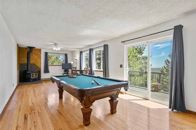 8386 S Davco Dr, Morrison, CO 80465 - playroom featuring a textured ceiling, a wood stove, billiards table, light wood finished floors, and ceiling fan