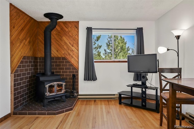 8386 S Davco Dr, Morrison, CO 80465 - living area with a wood stove, wood-type flooring, a textured ceiling, and baseboard heating