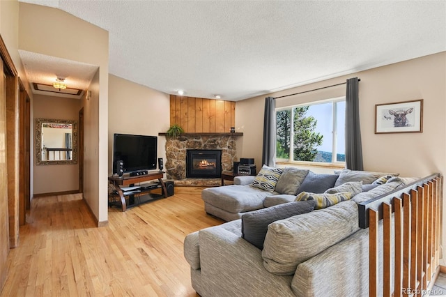 8386 S Davco Dr, Morrison, CO 80465 - living area with light wood-style floors, a textured ceiling, baseboards, and a fireplace