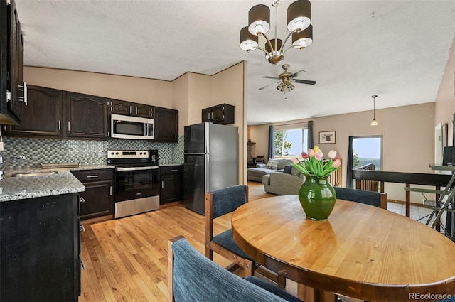 8386 S Davco Dr, Morrison, CO 80465 - dining room featuring light wood finished floors, ceiling fan, vaulted ceiling, a chandelier, and a textured ceiling