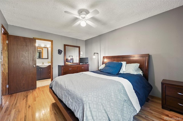 8386 S Davco Dr, Morrison, CO 80465 - bedroom with light wood-style floors, a textured ceiling, ensuite bath, and a ceiling fan