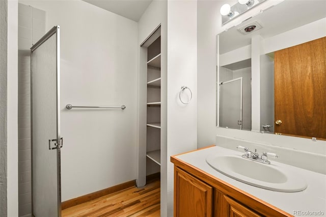 8386 S Davco Dr, Morrison, CO 80465 - full bathroom with wood finished floors, a stall shower, vanity, and baseboards