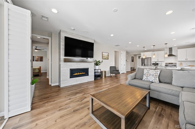 1925 Peregrine Dr, Brighton, CO 80601 - living area with recessed lighting, light wood-style flooring, a large fireplace, and ceiling fan