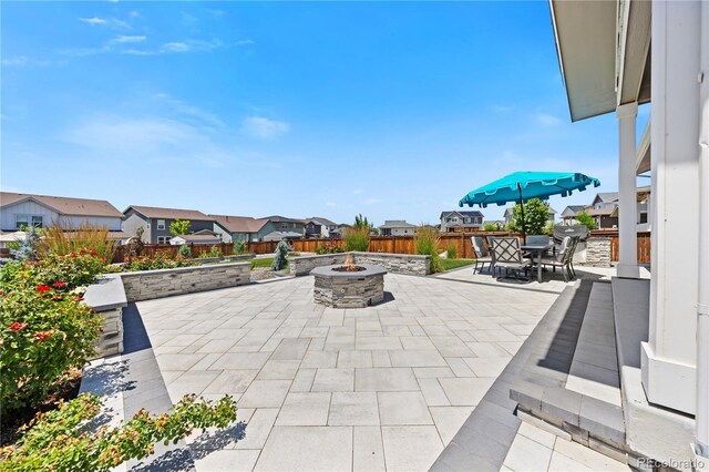 1925 Peregrine Dr, Brighton, CO 80601 - view of patio / terrace with a fire pit, outdoor dining space, and a residential view
