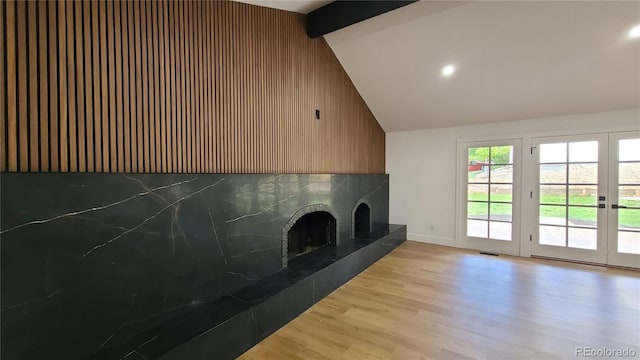 10297 W Crestone Mtn, Littleton, CO 80127 - unfurnished living room featuring a fireplace with raised hearth, beamed ceiling, wood finished floors, baseboards, and recessed lighting