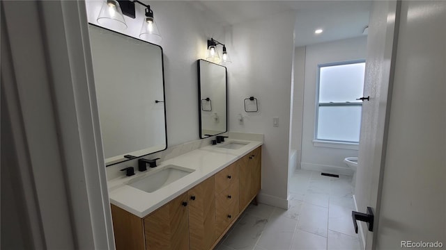 10297 W Crestone Mtn, Littleton, CO 80127 - full bathroom featuring marble finish floors, baseboards, double vanity, toilet, and recessed lighting