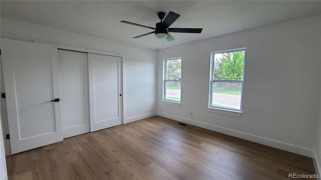 10297 W Crestone Mtn, Littleton, CO 80127 - unfurnished bedroom with baseboards, wood finished floors, a closet, and ceiling fan