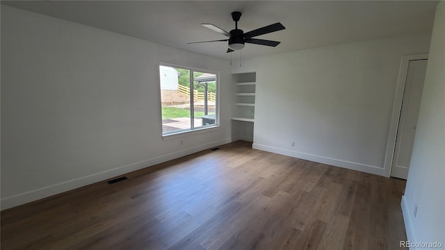 10297 W Crestone Mtn, Littleton, CO 80127 - unfurnished room featuring wood finished floors, baseboards, built in shelves, and a ceiling fan
