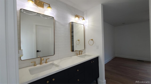 10297 W Crestone Mtn, Littleton, CO 80127 - full bath featuring double vanity, wood finished floors, decorative backsplash, and baseboards