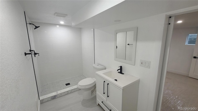 10297 W Crestone Mtn, Littleton, CO 80127 - bathroom with vanity, a tile shower, toilet, and recessed lighting