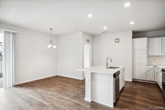 kitchen featuring light countertops, a sink, dark wood finished floors, dishwasher, and recessed lighting