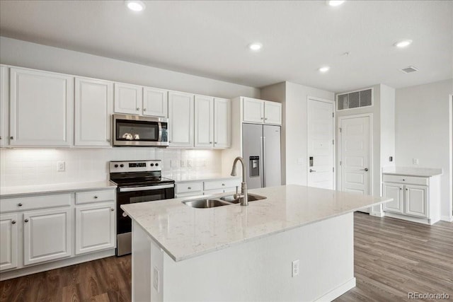 kitchen featuring dark wood-style flooring, a sink, white cabinetry, tasteful backsplash, and appliances with stainless steel finishes