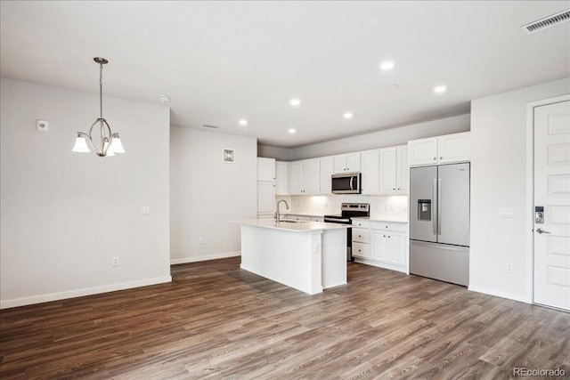 kitchen with stainless steel appliances, baseboards, visible vents, and wood finished floors