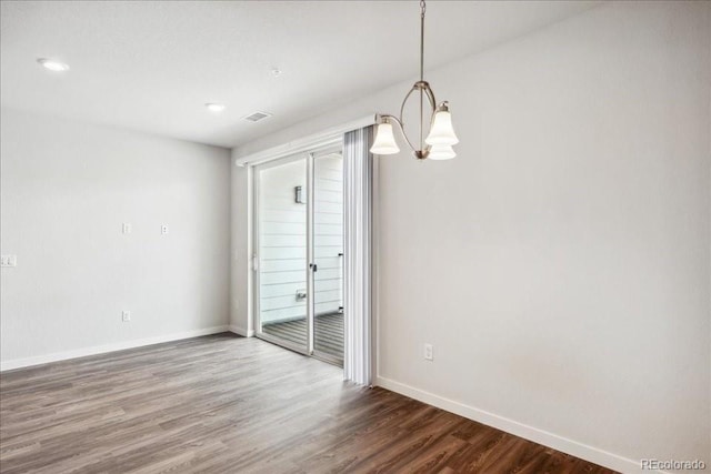 unfurnished dining area featuring wood finished floors, visible vents, recessed lighting, an inviting chandelier, and baseboards