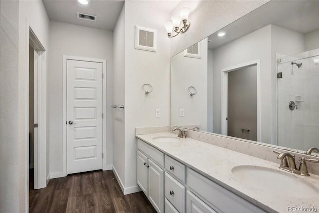 full bath with visible vents, a shower stall, and a sink
