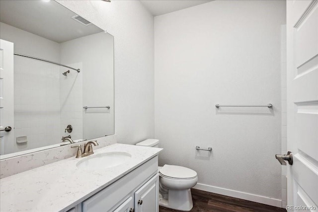 bathroom with toilet, wood finished floors, vanity, visible vents, and baseboards