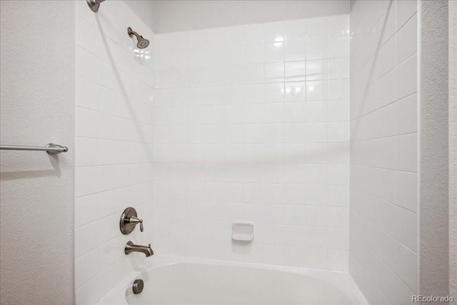 full bath with  shower combination and a textured wall