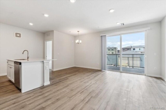 485 Interlocken Blvd Unit 209, Broomfield, CO 80021 - unfurnished living room with a sink, a chandelier, light wood-style flooring, baseboards, and recessed lighting