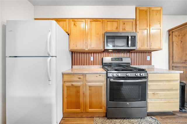 1777 Main St, Georgetown, CO 80444 - kitchen featuring appliances with stainless steel finishes, light countertops, light wood finished floors, and light brown cabinetry