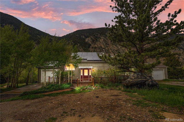 1777 Main St, Georgetown, CO 80444 - exterior space with a mountain view, an attached garage, roof mounted solar panels, and dirt driveway
