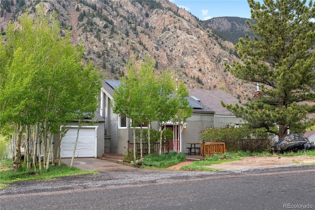 1777 Main St, Georgetown, CO 80444 - view of front of home featuring a garage, a mountain view, and driveway