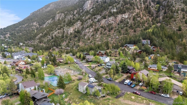 1777 Main St, Georgetown, CO 80444 - aerial overview of property's location featuring a heavily wooded area, a mountainous background, and nearby suburban area