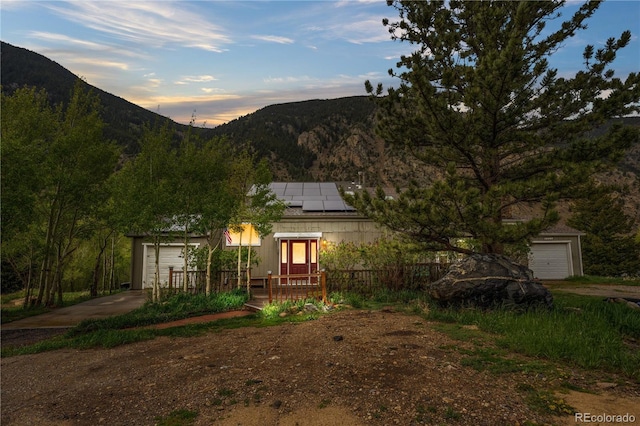 1777 Main St, Georgetown, CO 80444 - exterior space featuring a mountain view, a garage, roof mounted solar panels, and driveway