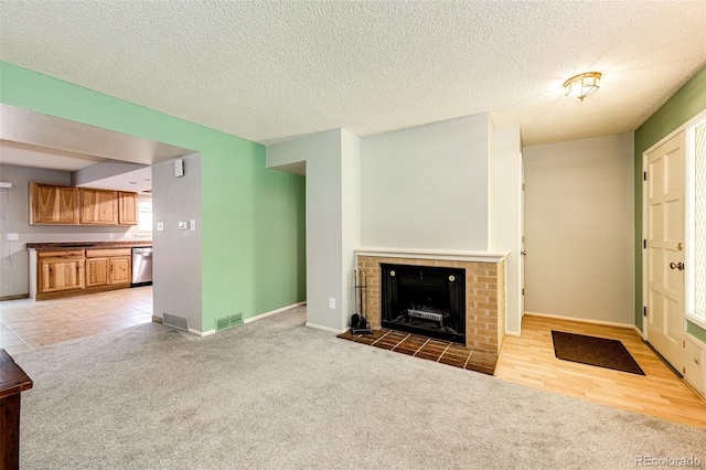 12632 W Virginia Ave, Lakewood, CO 80228 - unfurnished living room featuring a fireplace, light colored carpet, baseboards, and a textured ceiling
