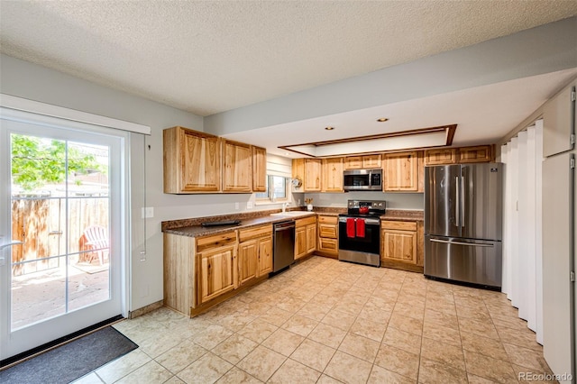 12632 W Virginia Ave, Lakewood, CO 80228 - kitchen with appliances with stainless steel finishes, a sink, a raised ceiling, dark countertops, and a textured ceiling