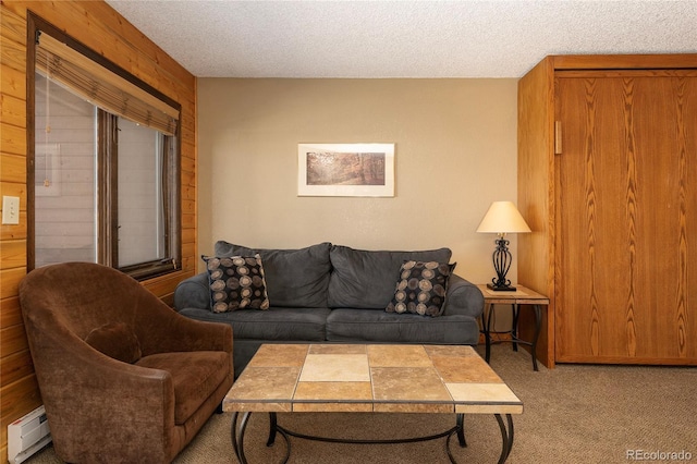 carpeted living room with a baseboard heating unit and a textured ceiling